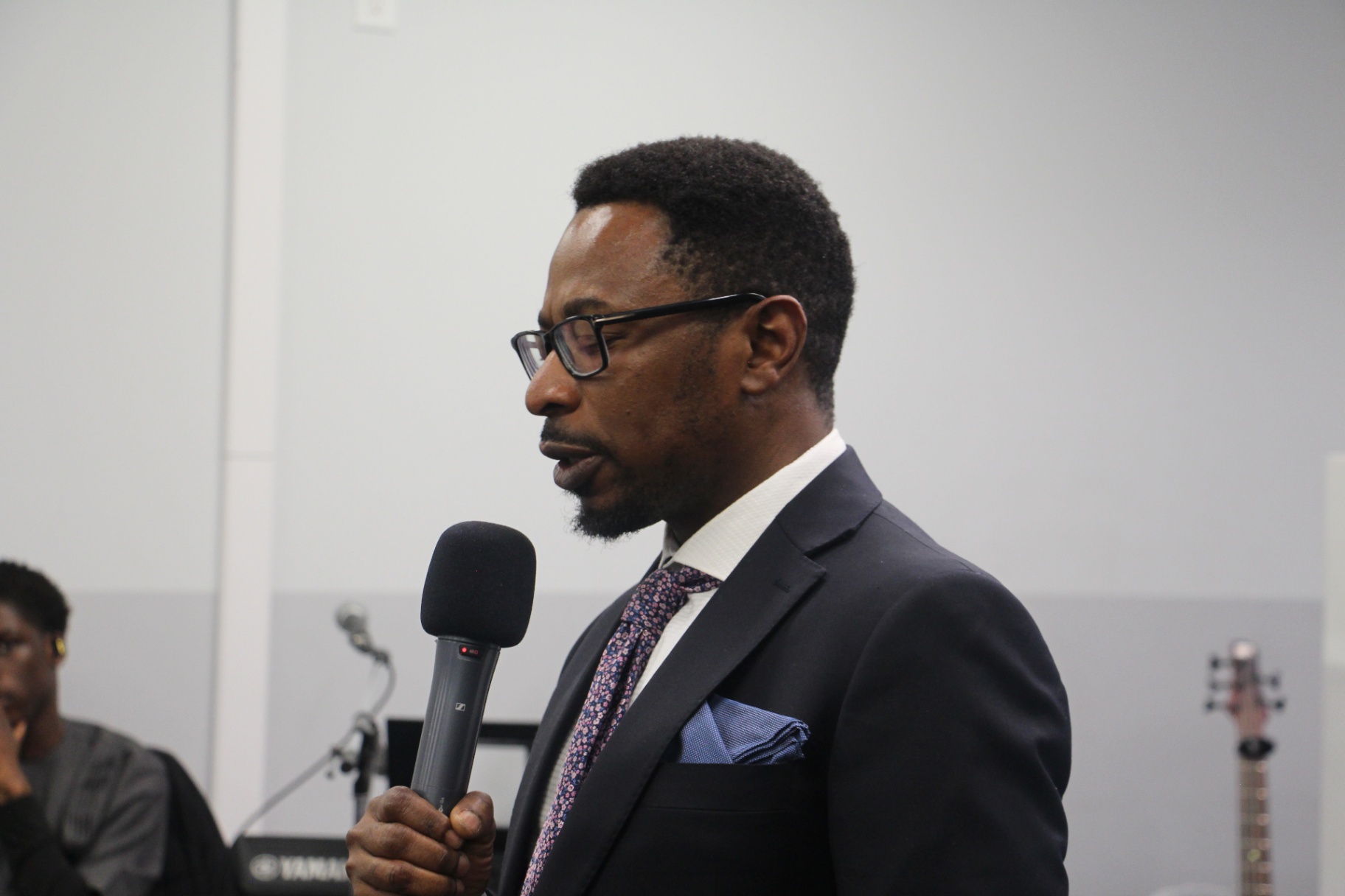 Minister speaking from the podium during Sunday worship at Open Heavens Chapel Edmonton